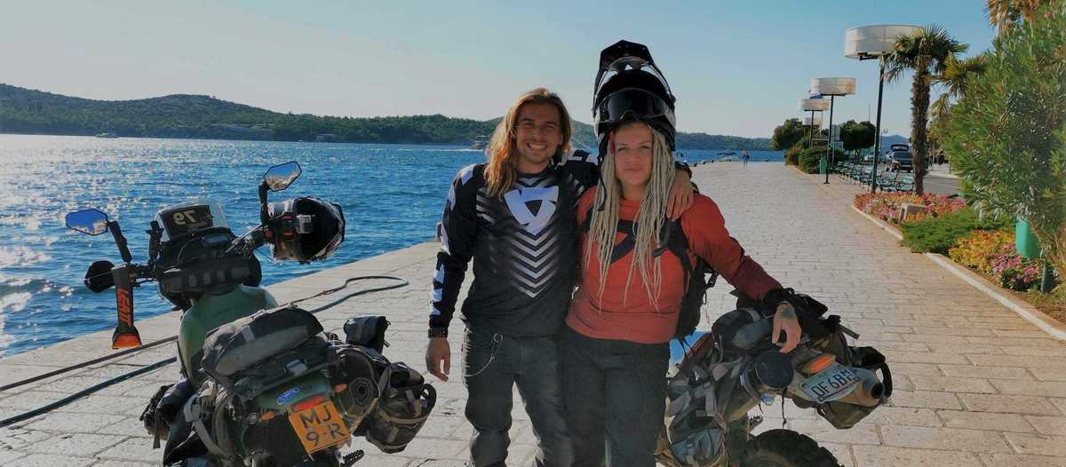 Zwei Motorradreisende mit ihren Enduros an der Küste
